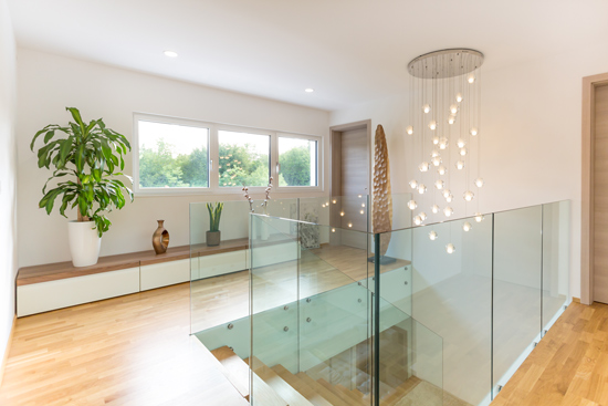 modern styled stairway and landing with wooden floors glass banners and hanging lights