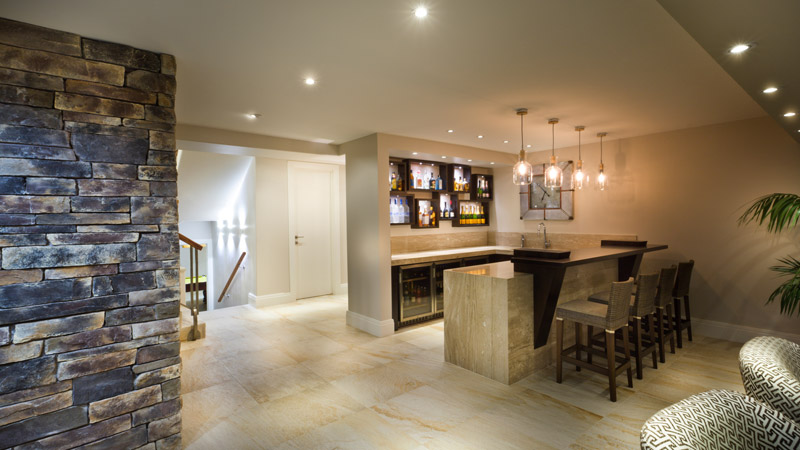 modern styled home bar with hanging lights, ceiling spot lights and bar stools